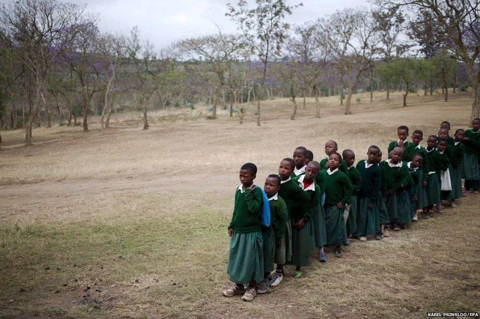 Tanzanian children wait to be immunised against measles and rubella