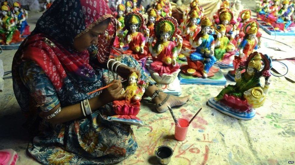 An Indian artist gives the final touches to a statue of Hindu Goddess Lakshmi, who represents wealth, at a workshop ahead of Diwali in Hyderabad on October 21, 2014.