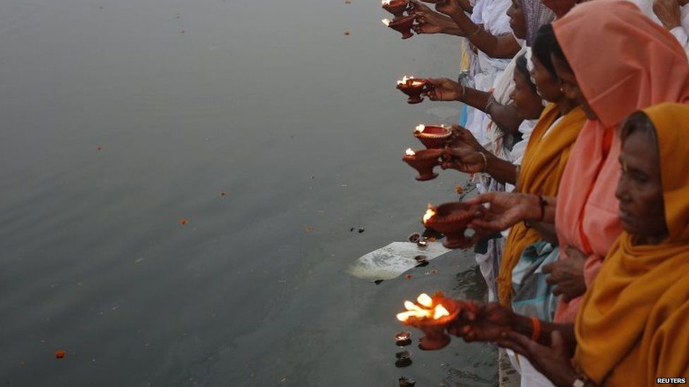 Widows, abandoned by their families, offer prayers on the banks of the river Yamuna as part of Diwali celebrations on October 21, 2014