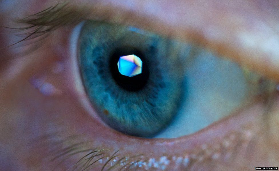 The eye of a scientist called Margarete Neu with a crystal on her pupil reflected from her computer screen