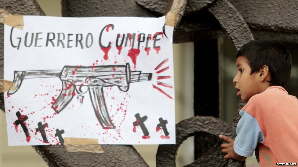 A child is seen next to a sign reading "Guerrero delivers" during a protest of teachers in demand of justice for the deaths of six people including students of Ayotzinapa and football players of the team 'Los Avispones' in Chilpancingo, Guerrero state, Mexico, on September 27, 2014.