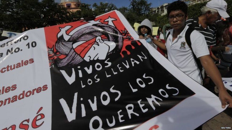 A student holds a banner which reads "They took them alive, we want them back alive" during a protest in support of missing students in Iguala on 11 November, 2014