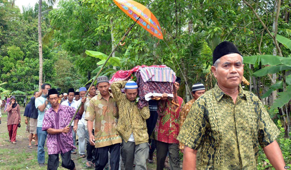 Relatives and villagers carry the coffin of Sumarti Ningsih