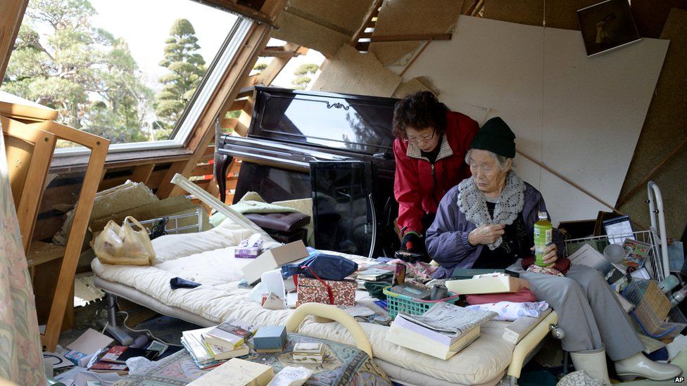 Residents organize scattered belongings in their collapsed house after the quake hit Hakuba, Nagano prefecture (23 November 2014)