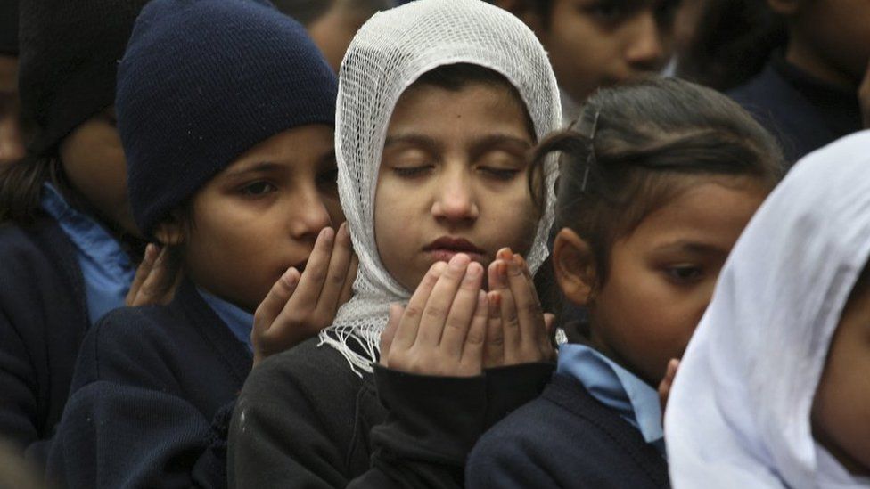 Pakistani students pray during a special ceremony for the victims of Tuesday's attack in Peshawar, at a school in Lahore - 17 December 2014