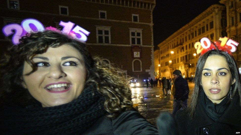 People cheer on the Piazza Venezia to celebrate the new year in Rome (01 January 2015)