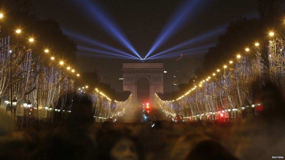 Revellers gather near the Arc de Triomphe on the Champs-Elysees Avenue in Paris (31 December 2014)