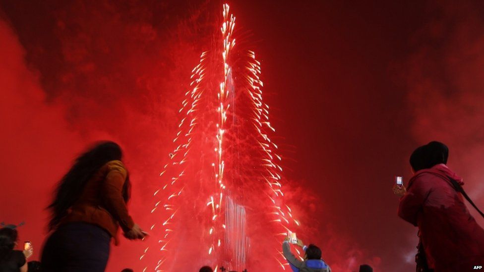 People watch as Dubai celebrates the new year with a light and sound extravaganza at midnight at the Burj Khalifa, the world"s tallest tower (31 December 2014)