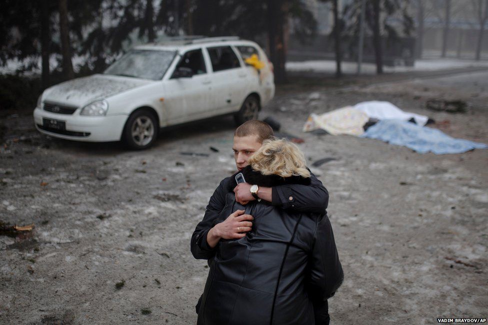 A rebel comforts the wife of a civilian killed by shelling in Donetsk, eastern Ukraine