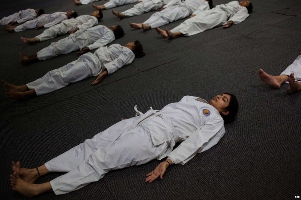 Indian policewomen perform a "savasana" during a self-defence class in New Delhi.