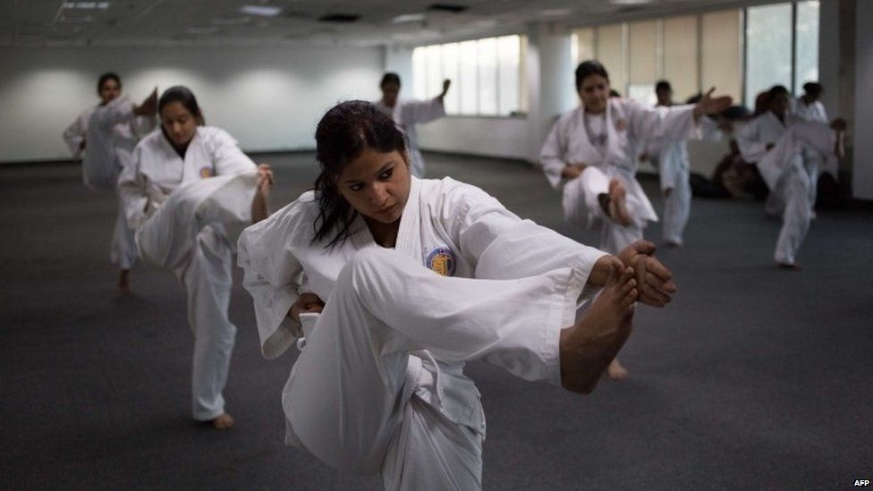 Indian policewomen practice kicks during a self-defence class in New Delhi