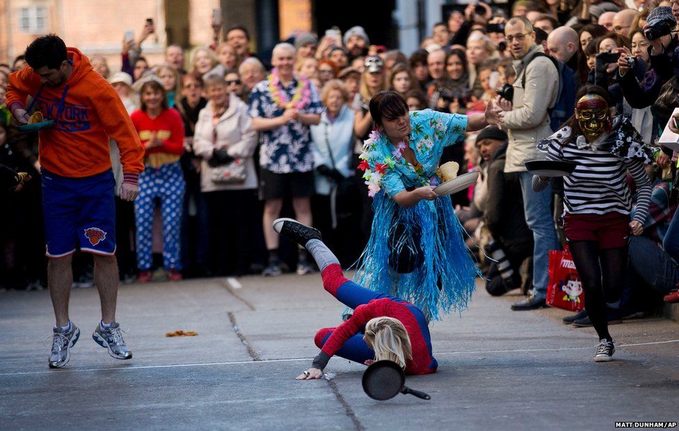 A participant falls whilst taking part in the fancy dress Great Spitalfields Pancake Race
