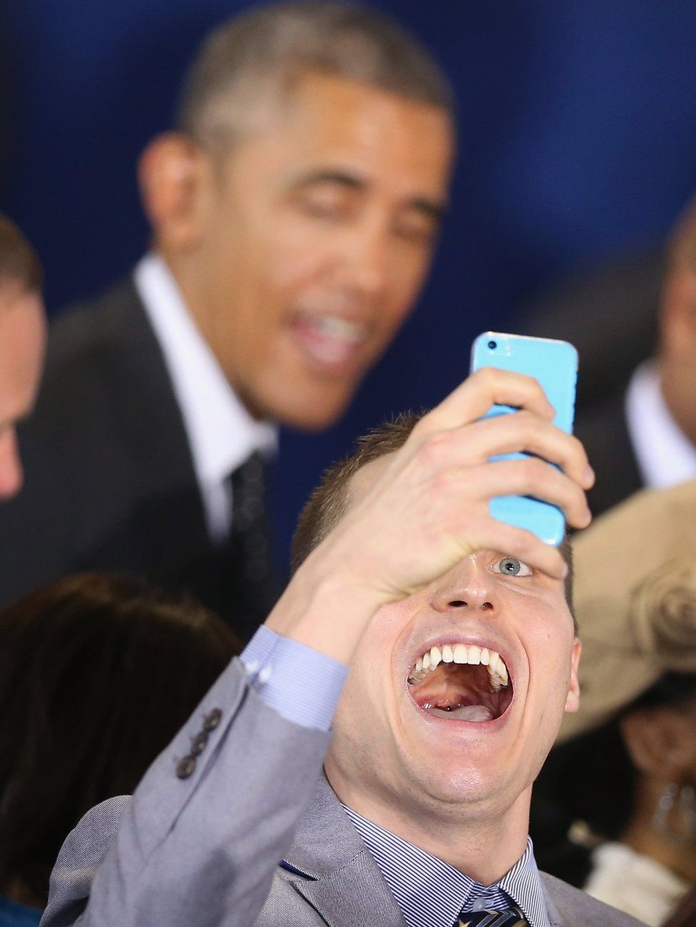 A man takes a selfie as US President Barack Obama walks past