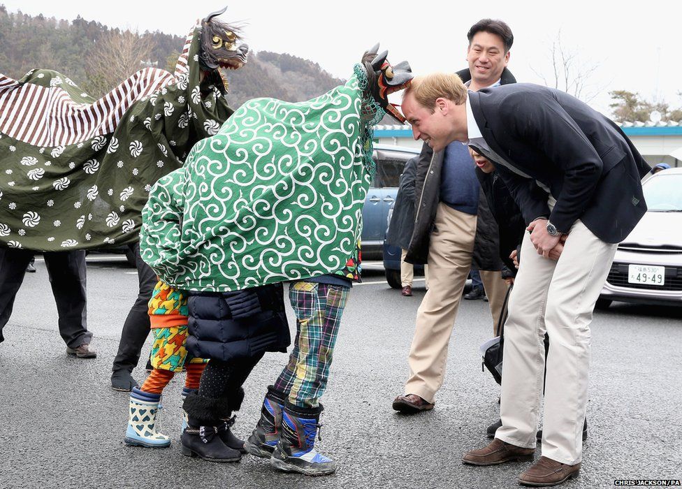 The Duke of Cambridge is greeted by Lion Dancers in Japan