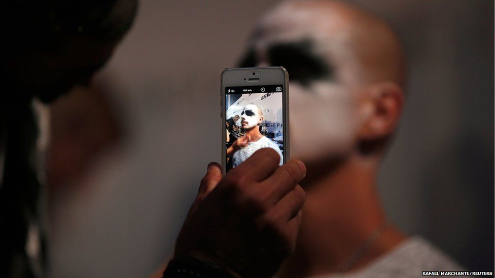 A model is pictured with a mobile phone during Lisbon Fashion Week