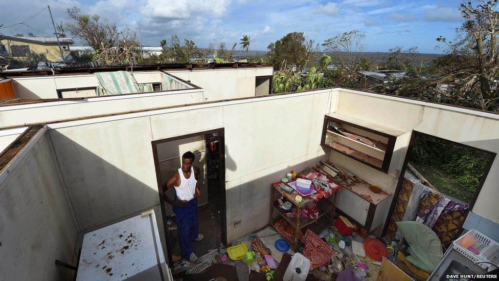 Uwen Garae stands in his home damaged by Cyclone Pam in Port Vila
