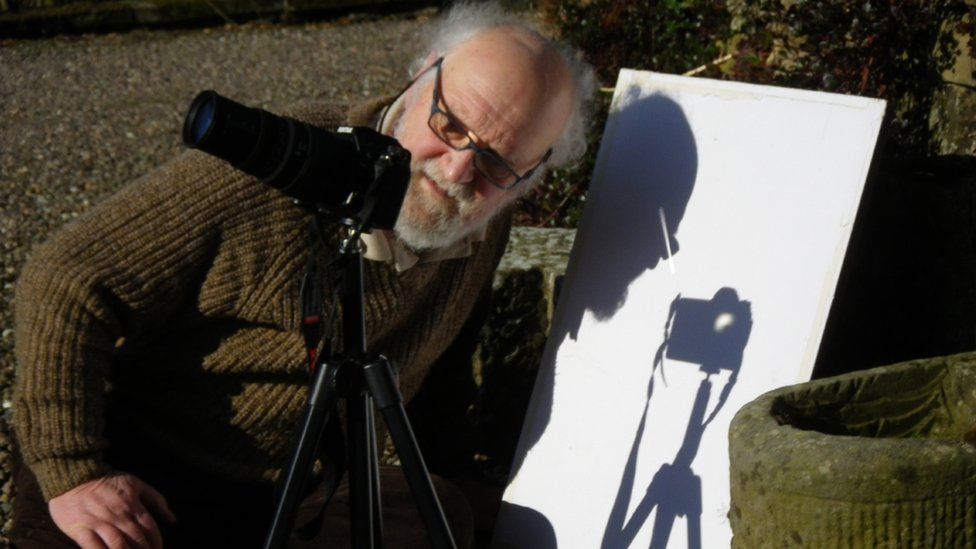 Man photographing eclipse