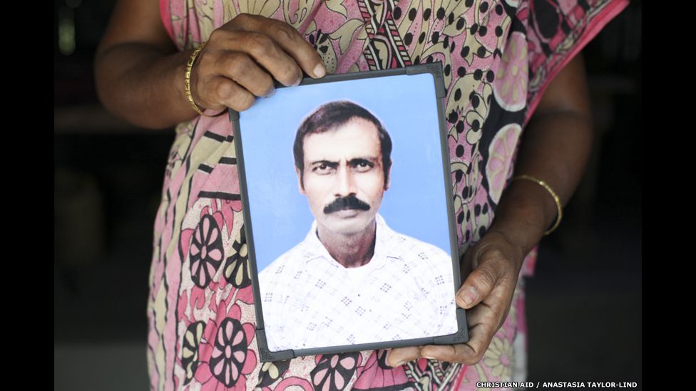 Sabitri Mondal holds picture of her husband