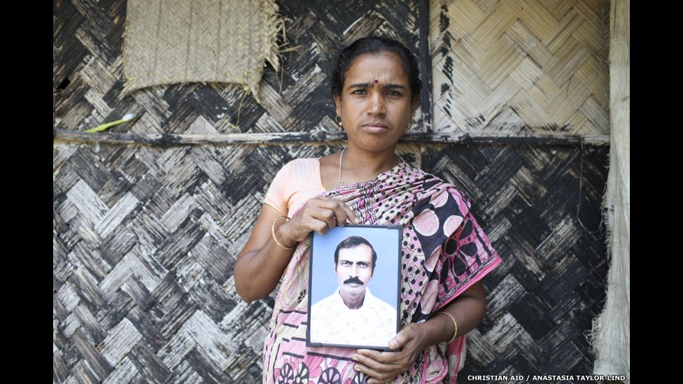 Sabitri Mondal holds picture of her husband who was killed by a tiger
