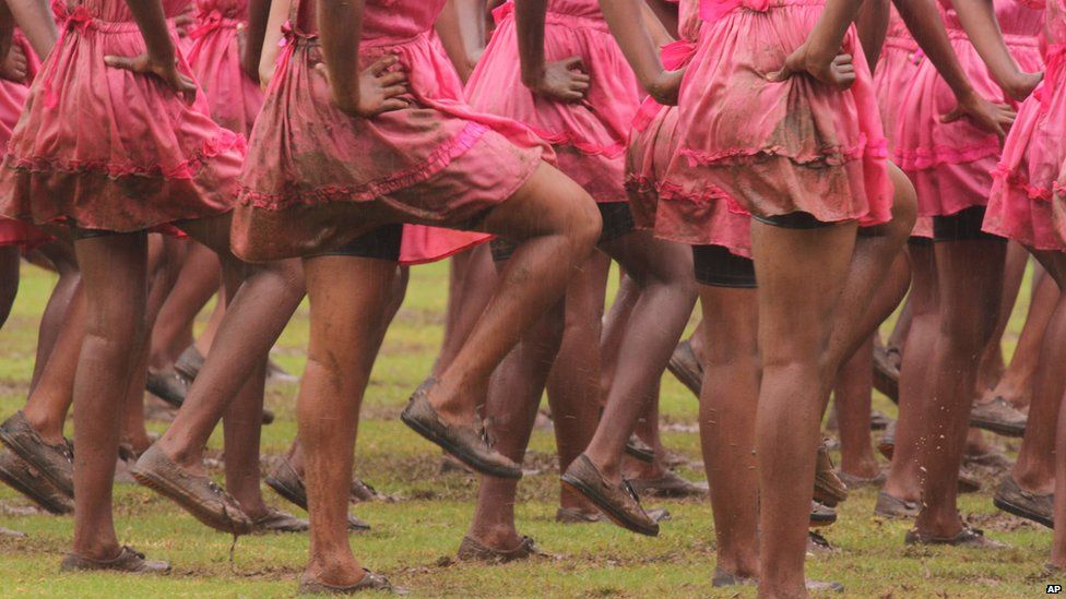 Girls with muddy uniforms marching in the rain at Harare's national sports stadium, Zimbabwe - Saturday 18 April 2015