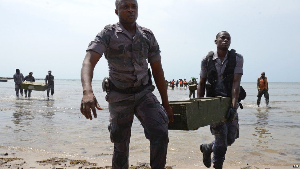 Security personnel carrying a box on a beach in Cape Esterias, Gabon - Tuesday 21 April 2015