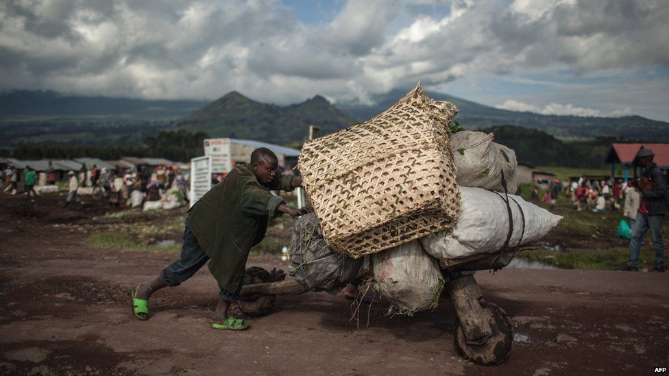 A man pushing a wooden scooter full of goods, Kibunga, DR Congo - Thursday 23 April 2015