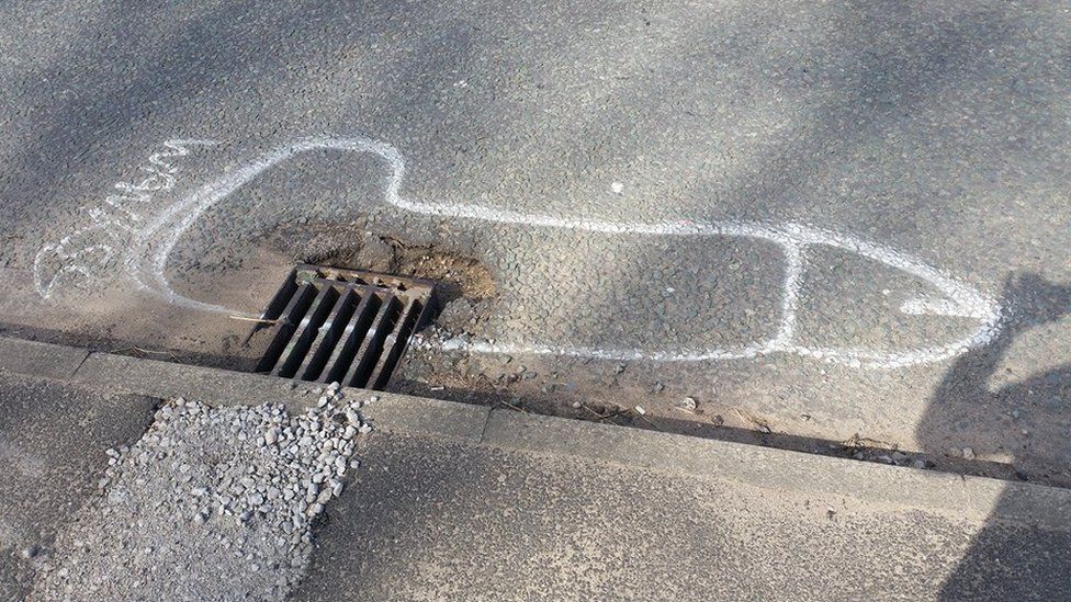 A penis drawn around a pothole