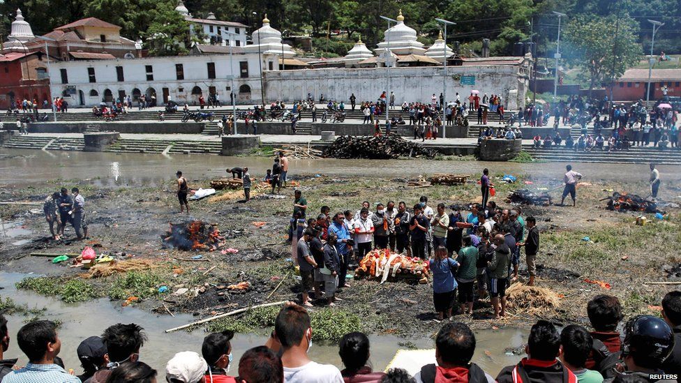 People pray before cremating the body of a victim of Saturdays earthquake, alongside a river in Kathmandu, Nepal (27 April 2015)