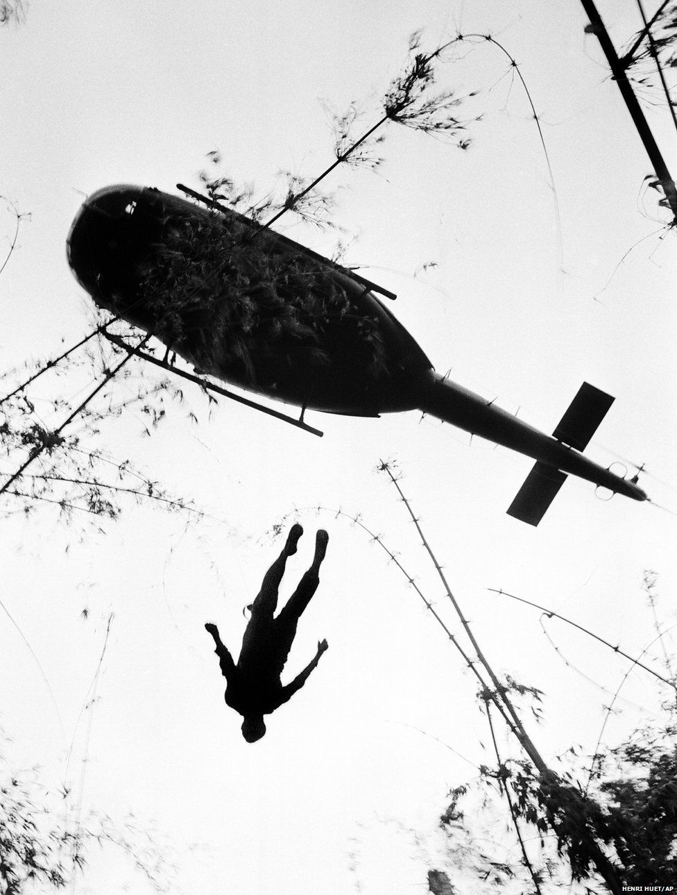 The body of an American paratrooper killed in action in the jungle near the Cambodian border is raised up to an evacuation helicopter in War Zone C, Vietnam, 14 May 1966