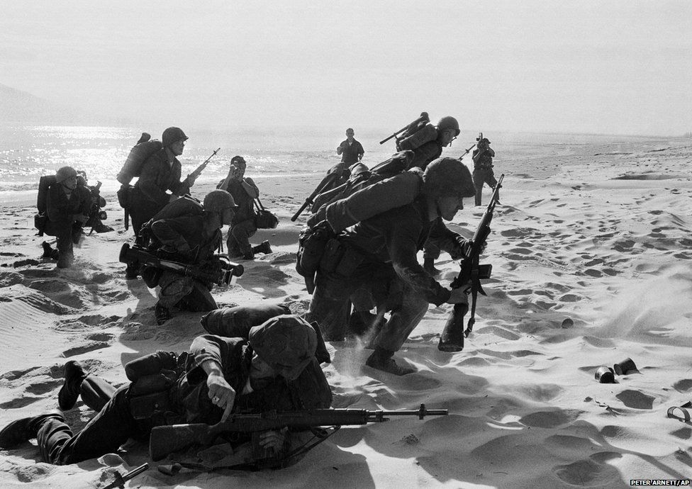 Freshly landed US Marines make their way through the sands of Red Beach at Da Nang, 10 April 1965. They were on their way to reinforce the air base as South Vietnamese Rangers battled guerrillas about three miles south of the beach.
