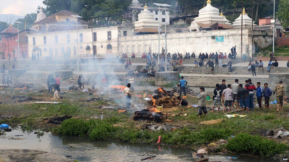People burn the bodies of earthquake victims at a mass cremation at Pashupatinath in Kathmandu on April 26, 2015.