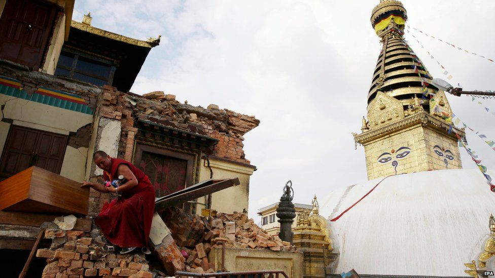 A monk salvages belongings from the rubble at Nepalese heritage site Syambhunaath Stupa, also known as monkey temple, after a powerful earthquake struck Nepal (26 April 2015)