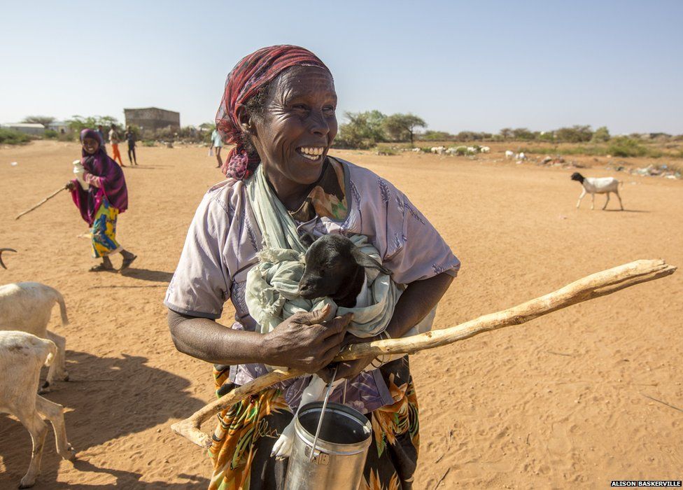 An elderly woman carries a new born