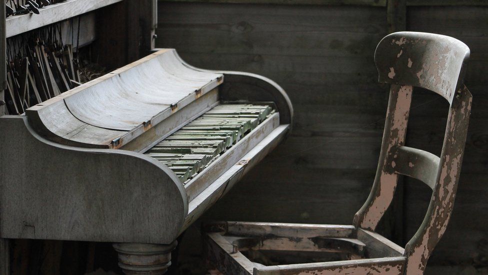 Piano and chair in a derelict house