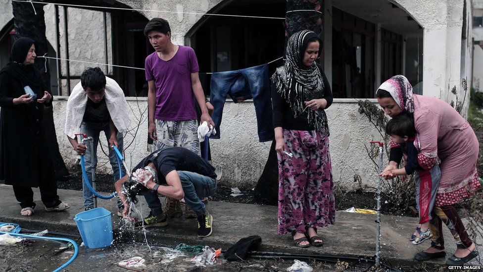 Migrants wash in the street