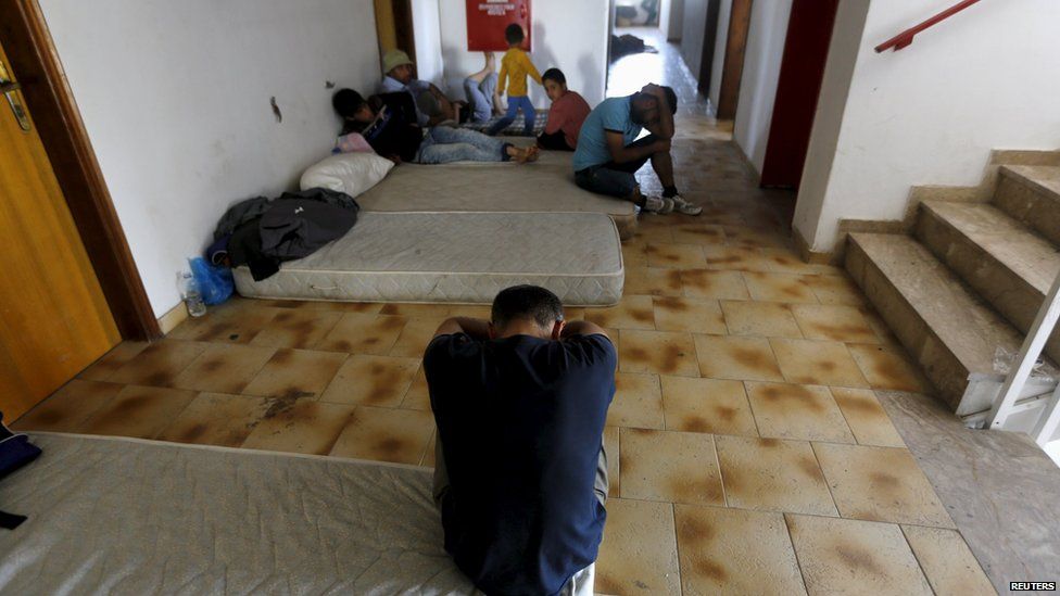 Migrants on mattresses in the former hotel where they are staying