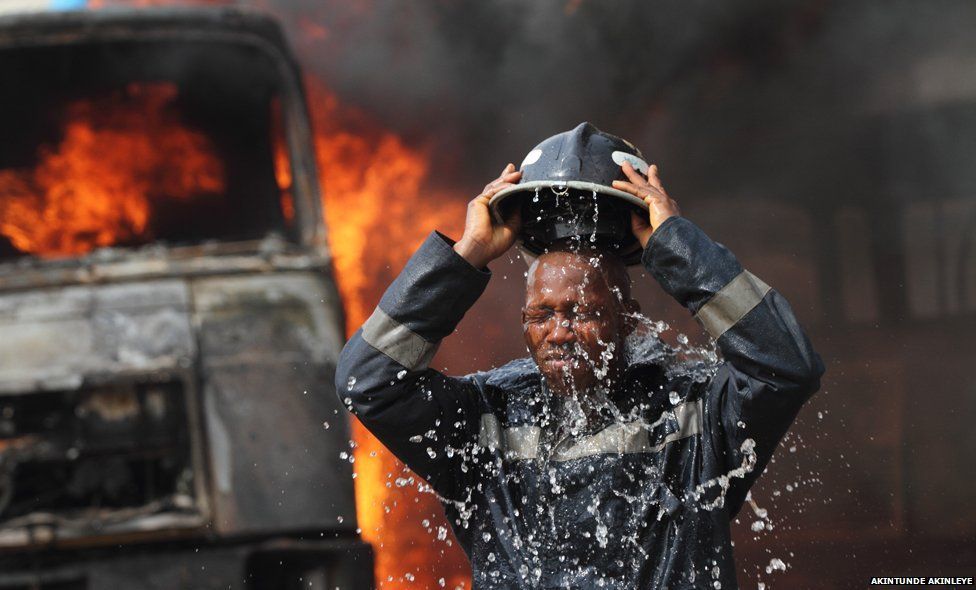 A fireman cools off after petrol tankers, belonging to an oil service company, caught fire at Ogba neighbourhood in Nigeria"s commercial capital Lagos February 2, 2010. No injuries were reported.
