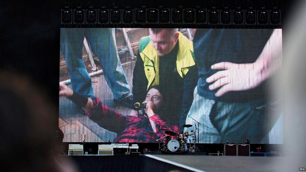 Dave Grohl is shown on the TV screen after his fall