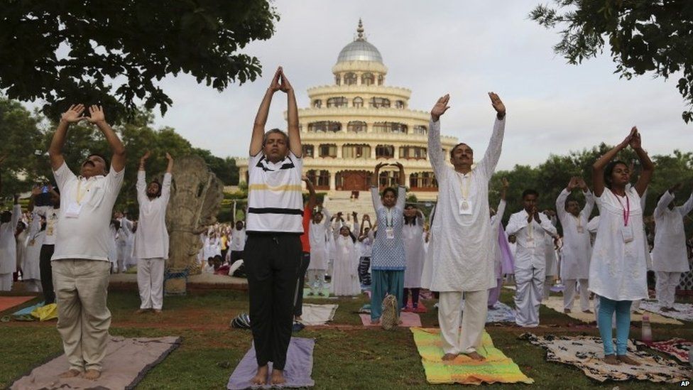 Yoga enthusiasts perform Surya Namaskar or sun salutation as they participate in a prelude to the International Yoga Day at the Art of Living headquarters on the outskirts of Bangalore, India, Saturday, June 13, 2015.