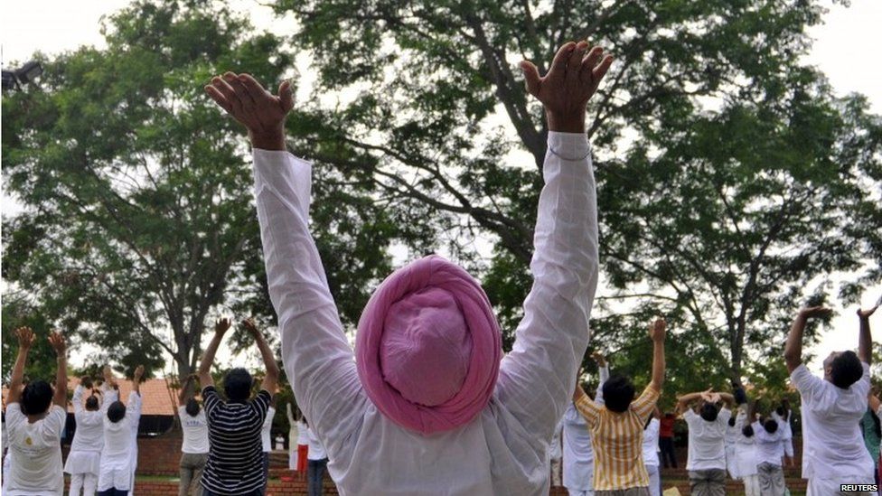 Participants perform a "Surya Namaskar" (sun salutation) during an early morning yoga session ahead of World Yoga Day, at the Art of Living ashram in Bengaluru, India, June 13, 2015