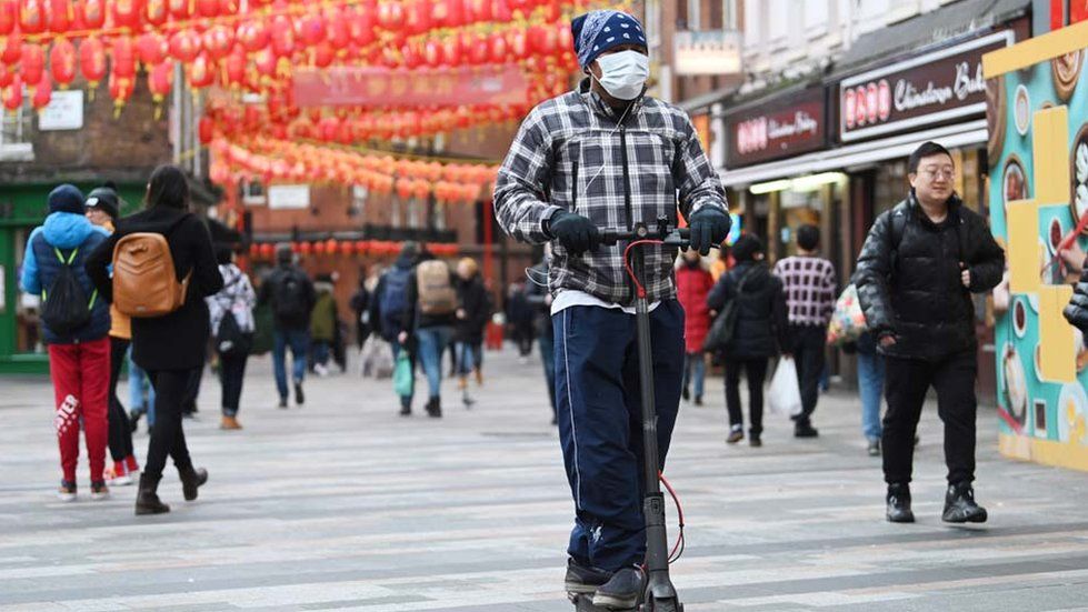 A man on a scooter wears a surgical mask in the Chinatown district of London, Britain, 29 January 2020.