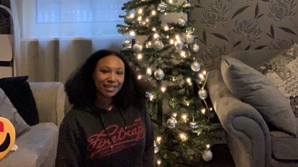 Shannon sitting next to her Christmas tree