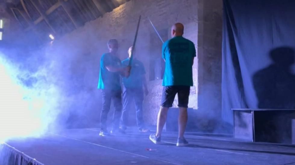 Macbeth and Macduff rehearsing their fight scene on a smoke-filled stage