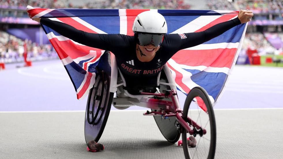 Samantha Kinghorn holding the flag of the United Kingdom aloft