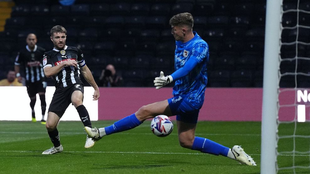 Dan Crowley of Notts County shoots through the legs of Grimsby goalkeeper Jordan Wright to score