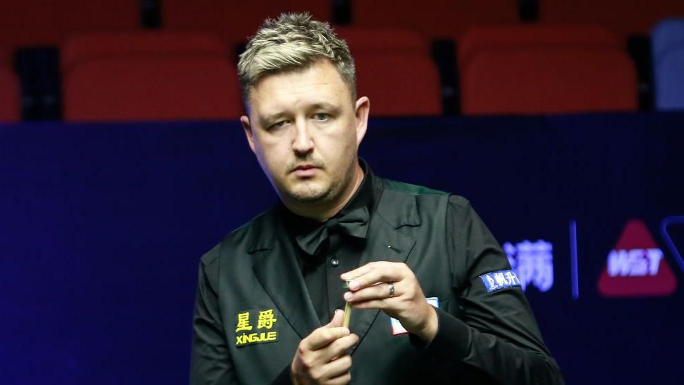 Kyren Wilson chalks his cue while assessing his next shot