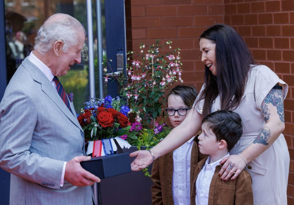 King Charles III receives gifts of flowers and Royal Engineer china mugs from the children of some of the barracks' serving soldiers during a visit 