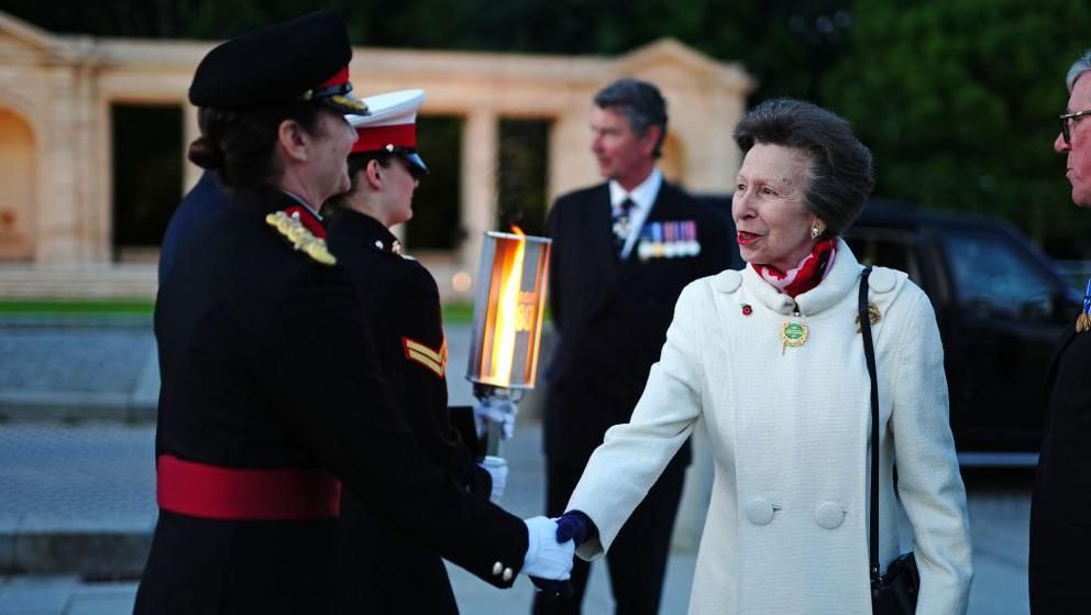 Princess Anne shakes hands with a woman in military dress