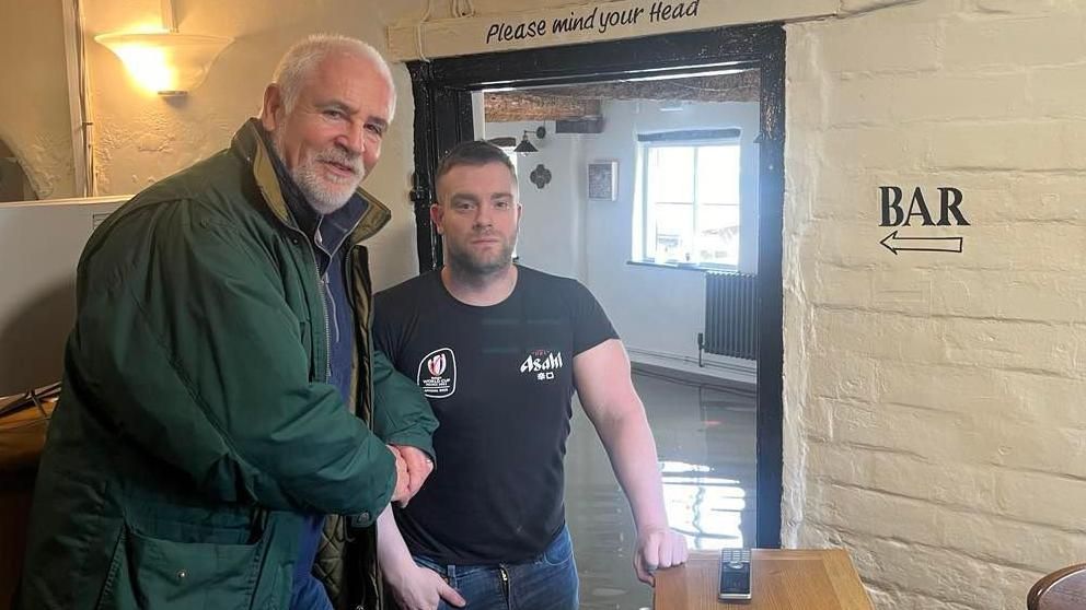 A councillor and landlord in a flooded pub