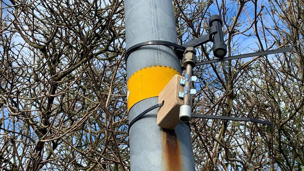 Equipment used to monitor air quality installed on a lamppost. It is a small gadget